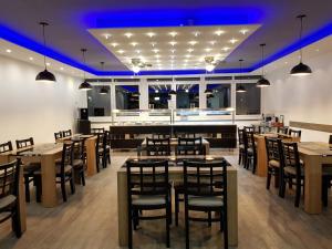 ein Esszimmer mit Tischen und Stühlen und blauer Beleuchtung in der Unterkunft Hotel Terminal One in Sindelfingen