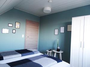 Gernrode - HarzにあるFerienwohnung Harzdomizilの青い壁のベッドルーム1室、ベッド1台、テーブル2台が備わります。