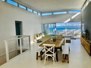 a living room with a table and chairs and the ocean at Seascape in De Kelders