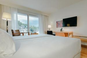 a hotel room with a large bed and a large window at Hesperia Ciudad de Mallorca in Palma de Mallorca