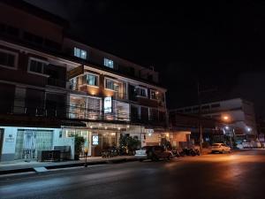 a building with cars parked on a street at night at Ban Kaew Guesthouse Songkhla in Songkhla