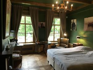 a bedroom with a bed and a chair and windows at Logement Swaenenvecht in Utrecht
