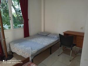 波隆納魯沃的住宿－酷達亞旅館，一间卧室配有一张床、一张桌子和一把椅子