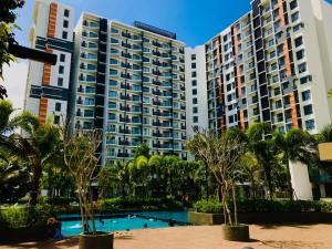 a large apartment building with a swimming pool and palm trees at Studio1111@TimurBay in Kuantan