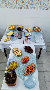 a table with several plates of food on it at Pousada Brasil - Self Check-in in Aparecida