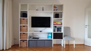 uma sala de estar com um centro de entretenimento branco com uma televisão em Haus Weyers em Kressbronn am Bodensee