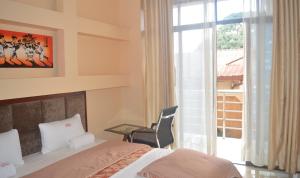 a bedroom with a bed and a chair and a window at Okla Extreme Hotel in Kampala +52 photos