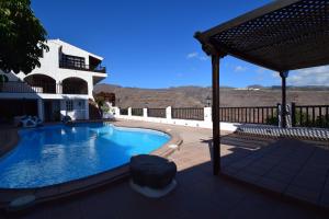 a swimming pool in front of a house at Villa Altos de Santiago in Playa de Santiago