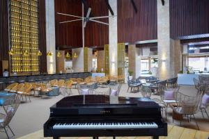 a piano in a lobby with tables and chairs at Grand Bavaro Princess - All Inclusive in Punta Cana