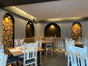 a dining room with wooden tables and white chairs at Roberto Hotel in Sinaia