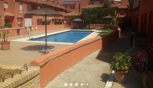 a swimming pool in a courtyard with an umbrella at Rinconcito Roteńo in Rota