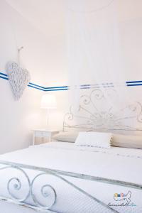 una camera da letto con un letto bianco con un cuore sul muro di Casa Tellina a Marina di Campo