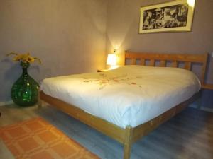 una camera da letto con un letto bianco e un vaso con fiori di Garibaldi n°12 a Volterra