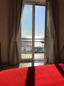 a bedroom with a red bed and a view of the ocean at Casa sul mare in Salerno