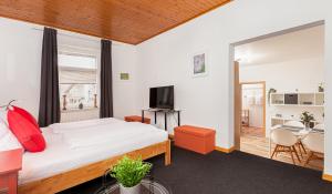 1 dormitorio con 1 cama, TV y mesa en Hotel Rutherbach en Essen