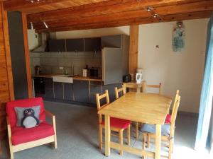 a kitchen and dining room with a wooden table and chairs at Appartement 58m2 avec jardin & terrasse dans chalet in Montgenèvre