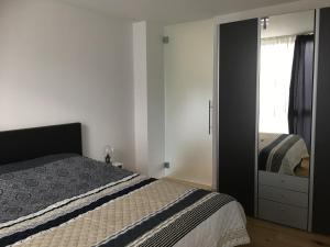una camera con letto, cassettiera e specchio di Appartement met groot terras a Mortsel