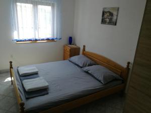 a bedroom with a bed with two towels on it at Apartmani Emily in Jezera