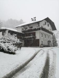un edificio con nieve en el suelo delante de él en Arbeiterzimmer Vintage Gästehaus, en Murau
