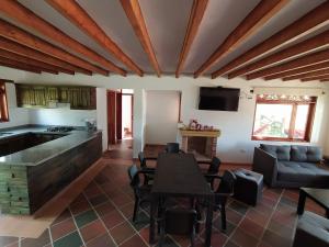 eine Küche und ein Wohnzimmer mit einem Tisch und einem Sofa in der Unterkunft Villa Fortuna in Villa de Leyva
