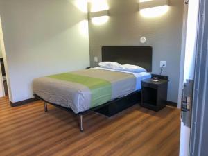 a bedroom with a bed with a green and white blanket at Studio 6 Wichita, KS - Airport in Wichita
