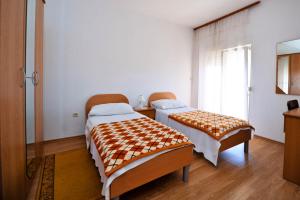 1 dormitorio con 2 camas y ventana en Dorica Dabo, en Novalja