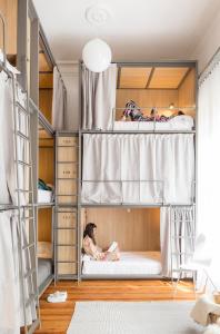 a child sitting on a bed in a bunk bed room at Franca City Hostel in Buenos Aires