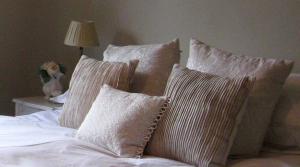 a bed with four pillows on top of it at Oundle Bespoke Apartments in Oundle