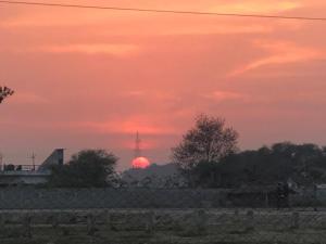 a sunset with the sun setting in the distance at Living Green Farms in Allahābād +3 photos