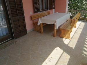 a table and a bench on a patio at Apartmani Emily in Jezera