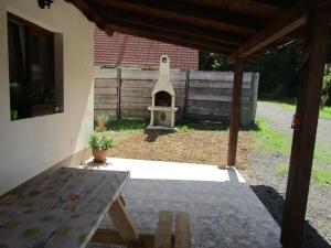 un patio trasero con una mesa y una casa de aves en Rekreační dům v Brdech Pod Svatou Annou, en Ohrazenice