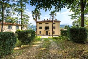 VILLA TURRI - Luxury Country & Padel Resort في Camporgiano: اطلالة خارجية على منزل به اشجار