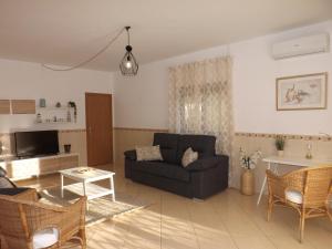 a living room with a black couch and a table at Villa Claramar in Albufeira