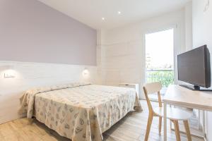 a bedroom with a bed and a desk and a television at Evo Boutique Hotel & SPA in Bellaria-Igea Marina