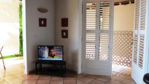 a television in a living room with a door at Anse Figuier Gites de France in Terre-de-Haut