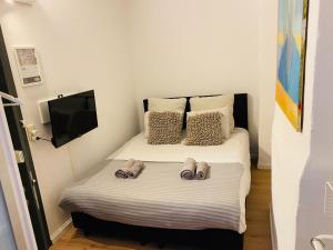 Un pequeño dormitorio con una cama con zapatillas. en Roture 88, en Lieja
