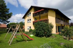 a house with a playground in front of it at Pension Zöllner Garni in Weismain