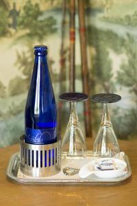 una botella azul en una bandeja junto a dos vasos en Logies Noorderlicht, en Damme