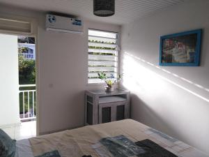 a bedroom with a bed and a window at Résidence Belle Anse, F3 sans vis à vis, vue mer in La Trinité