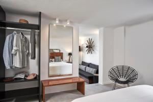 a bedroom with a mirror and a bed at Almyra Guest Houses in Paraga