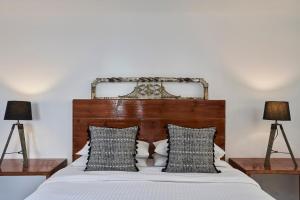 a bedroom with a bed with two lamps at Almyra Guest Houses in Paraga