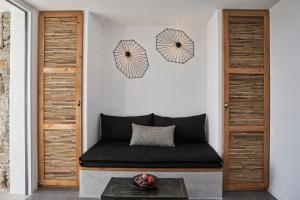 a room with a black couch and two umbrellas on the wall at Almyra Guest Houses in Paraga