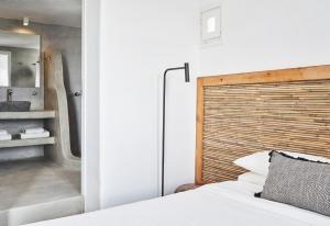 a bedroom with a bed and a bathroom with a sink at Almyra Guest Houses in Paraga