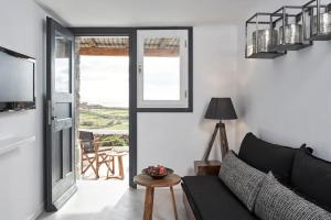 a living room with a couch and a sliding glass door at Almyra Guest Houses in Paraga