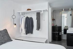 a room with a bed and a closet with clothes at Almyra Guest Houses in Paraga
