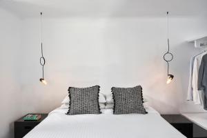 a bedroom with a bed with two black and white pillows at Almyra Guest Houses in Paraga