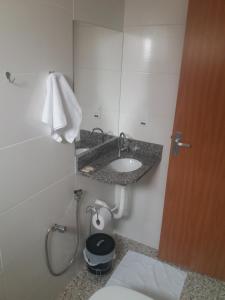 a bathroom with a toilet and a sink and a shower at FlatsCidade in Passos