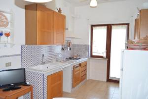 een keuken met houten kasten, een wastafel en een raam bij Bright 3 Bedrooms Apartment with Seaview Balcony in Sorrento