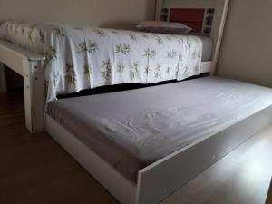 a bed with a white bed frame and a desk at Casa do Henrique 3 in Sorocaba