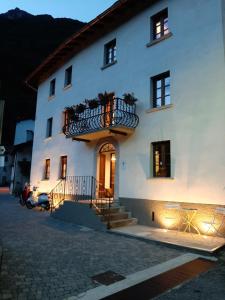 a white building with a balcony on the side of it at Casa Pasini-Foresteria in Piuro